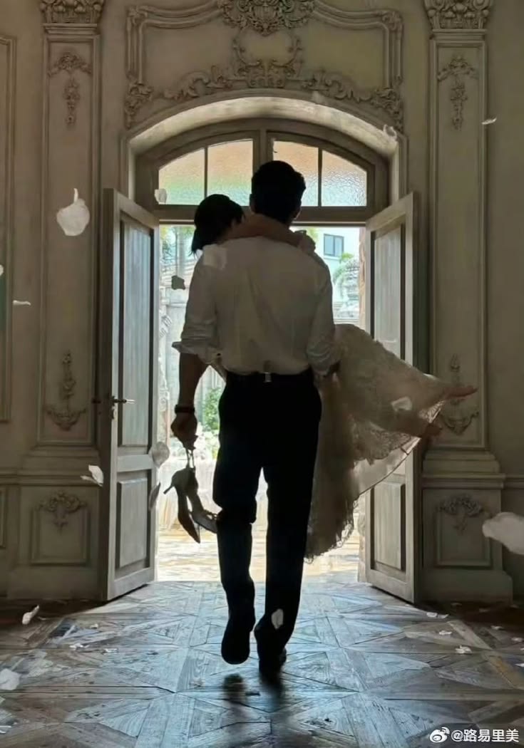 One person carrying the other through a tall ornate doorway, confetti in the air.